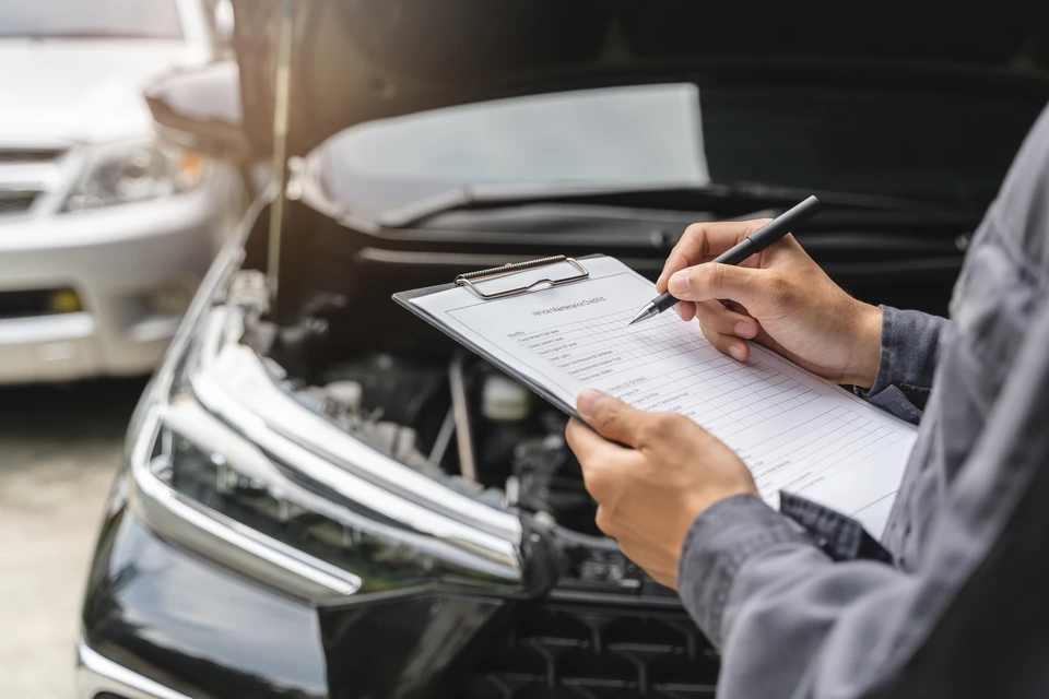 Mécanique à l'aide d'une clé de serrure pendant qu'on travaille sur un moteur de voiture à l'atelier de garage, les services de voiture et le concept de contrôle de maintenance